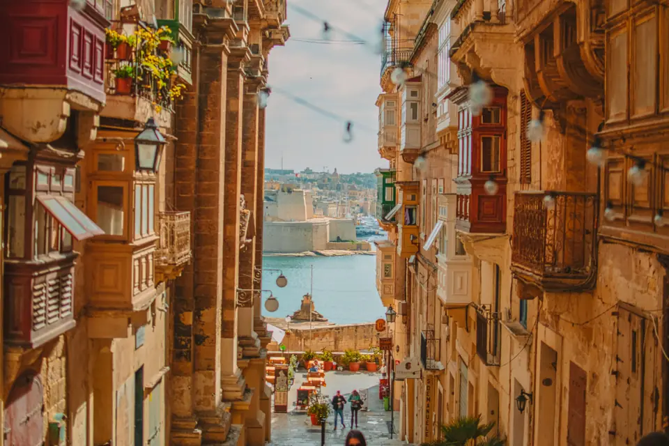 Rua estreita de Valletta com varandas tradicionais de madeira